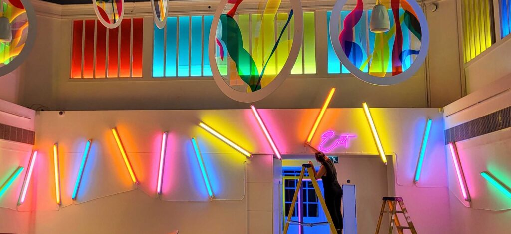 woman installing light tubes with colourful gels