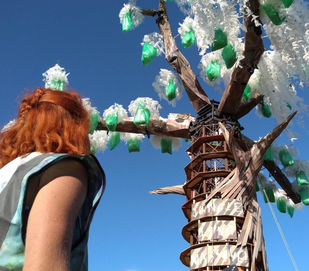 woman gazing up at a light tree